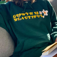 Load image into Gallery viewer, Girl wearing a green hoodie reading a book with flower prints and quote
